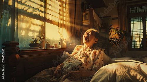 old east asian woman yawns, subtle warmth of morning sunlight streaming in through a bedroom window. photo