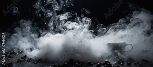 Smoke rising from a coffee cup in darkness