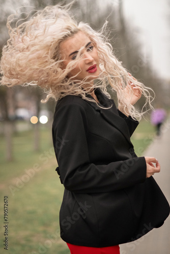 Portrait of a malty beautiful blonde girl on a city street. photo