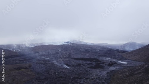 Cinematic Aerial Smoking Steaming Lava Field Active Volcano Dark Moody Misty Region. Otherworldy Fantasy Alien World Landscape. 4K High Quality Color Corrected. photo