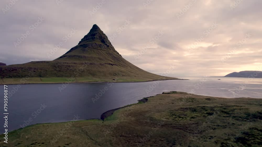 Kirkjufell Iceland Famous Mountain at Sunset. Aerial Flight Over Grass. Drone View Over River Landscape. Kirkjufell Iceland Famous Mountain at Sunset. Aerial Flight Over Grass. Drone View Over River Landscape.