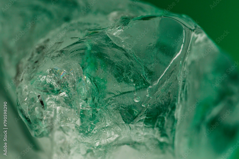 Chrystal clear frosty textured natural ice block in cold light green tones, isolated on black background. Chrystal clear frosty textured natural ice block in cold light green tones, isolated on black background.