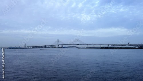 Wallpaper Mural Overcast skies over calm waters with a distant suspension bridge, serene scene Torontodigital.ca
