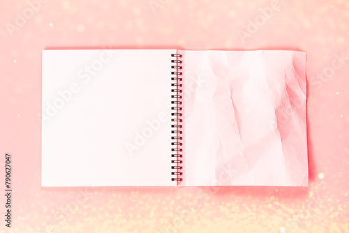 Open notebook with whole page and rumpled. An empty layout template for spiral notebook on pink background with sparkles.