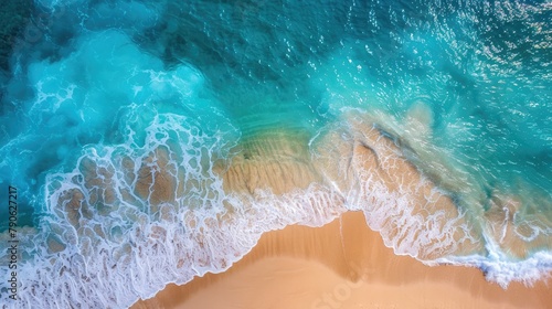 Aerial view of a sandy beach with clear blue water textures
