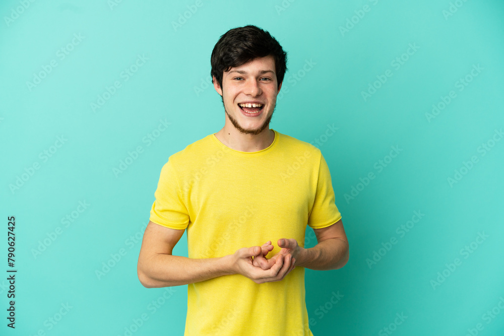 Young Russian man isolated on blue background laughing Young Russian man isolated on blue background laughing