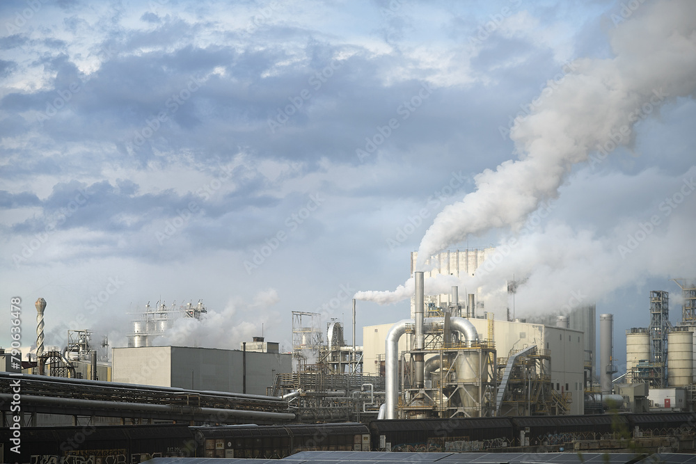 Industrial Factory Emits Smoke Against Cloudy Sky