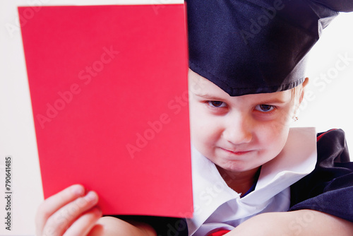Portrait of serious child girl judge (lawyer) with red card as symbol of disqualification for violation of the law. Humorous photo. Horizontal image.