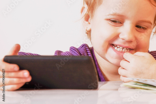 Portrait of happy baby girl with smart phone.