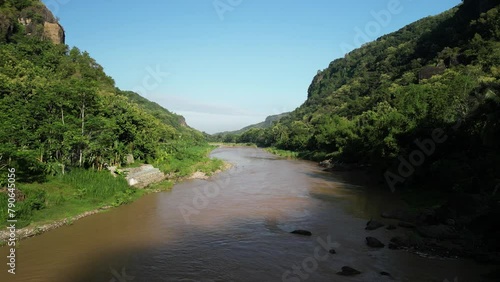 4k video Aerial view of Oya River Imogiri Jogja surrounded by Dense natural forest trees on the mountain hills with morning sunlight. Concept for International Day of Forest, World Environment Day. photo