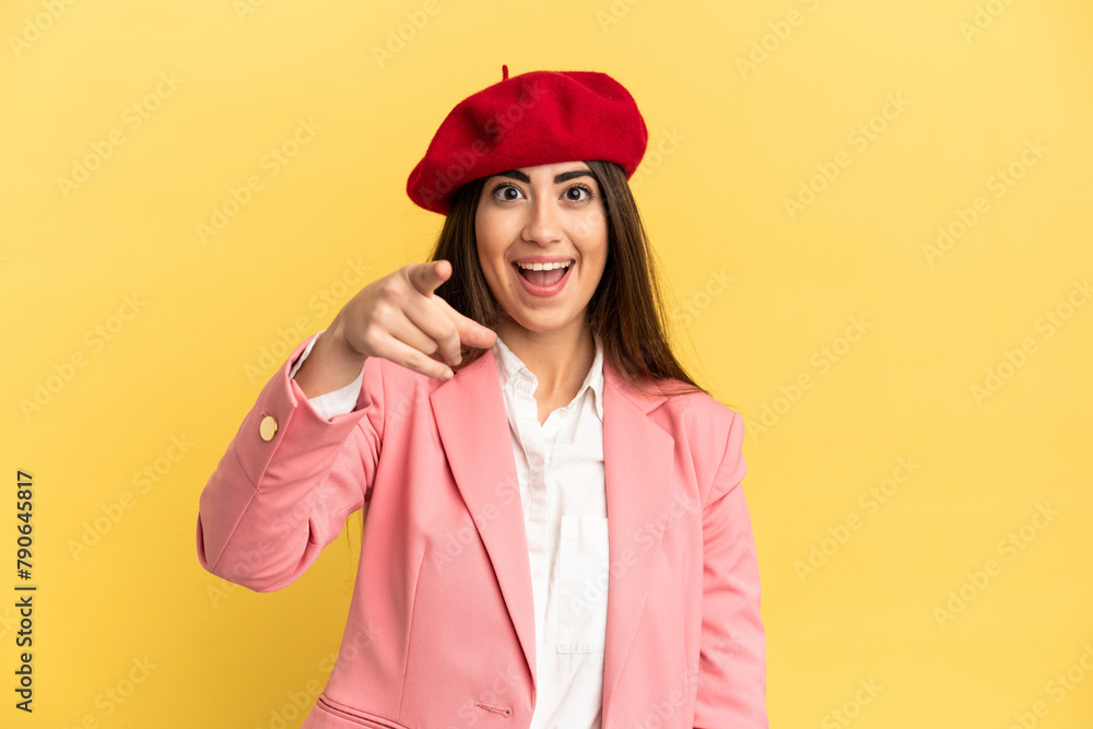 Young caucasian woman isolated on yellow background surprised and pointing front Young caucasian woman isolated on yellow background surprised and pointing front