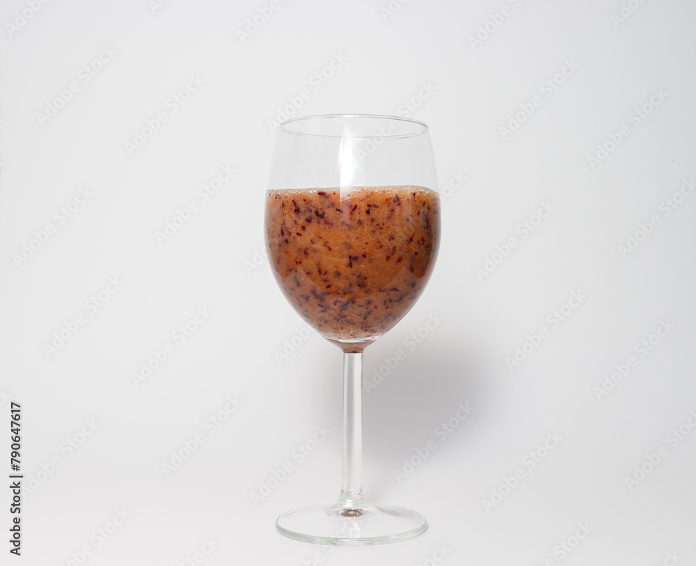 Blue berry smoohie in wine glass against white background Blue berry smoohie in wine glass against white background