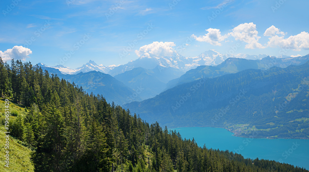 View over wooded mountain hills to Lake Thun and the Bernese Alps. Landscape on the Niederhorn View over wooded mountain hills to Lake Thun and the Bernese Alps. Landscape on the Niederhorn