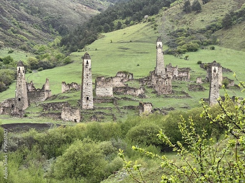 View of the medieval Targim tower complex in the Caucasus mountains surrounded by greenery. The Caucasus Mountains on a cloudy day in Ingushetia. Russia photo