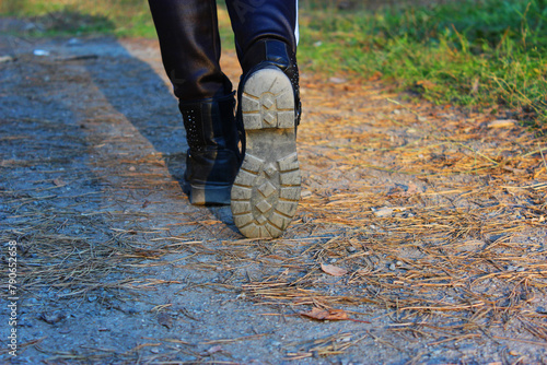 Foot boots walking on a dirt road in a forest with pine needles. Outdoors with nature in the background. Close up women's hike outdoors. Time alone in nature.concept.Banner