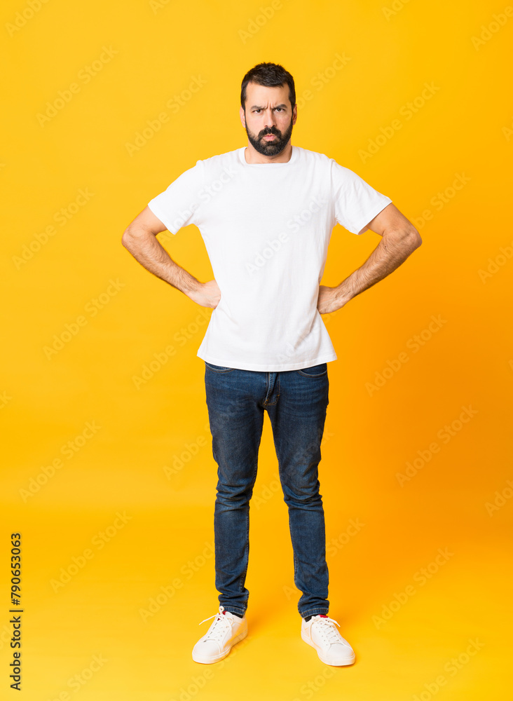 Full-length shot of man with beard over isolated yellow background angry - obrazy, fototapety, plakaty 