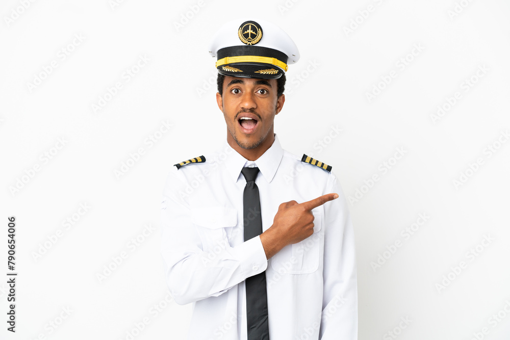 African American Airplane pilot over isolated white background surprised and pointing side
