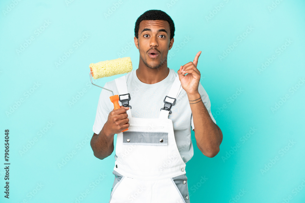 African American painter man over isolated blue background intending to realizes the solution while lifting a finger up African American painter man over isolated blue background intending to realizes the solution while lifting a finger up