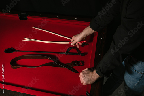 Adult man selecting accessories for punishment