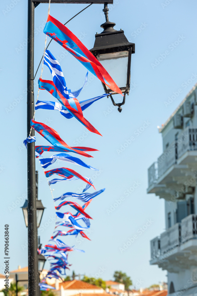 Local flags and ensign in Spetses island during the festivities for the most popular local festival, the Armata. The Greek flag and the local flag of the island are on display.