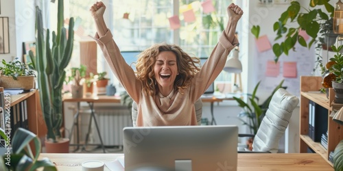 One mixed-race Afro-haired African American entrepreneur savoring a workplace success. Hispanic woman utilizing a desktop successfully. Happy woman shouting yes photo