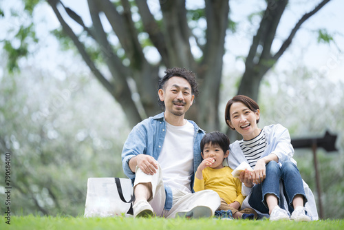 公園でピクニックをする家族 春夏のお出かけやレジャーのイメージ