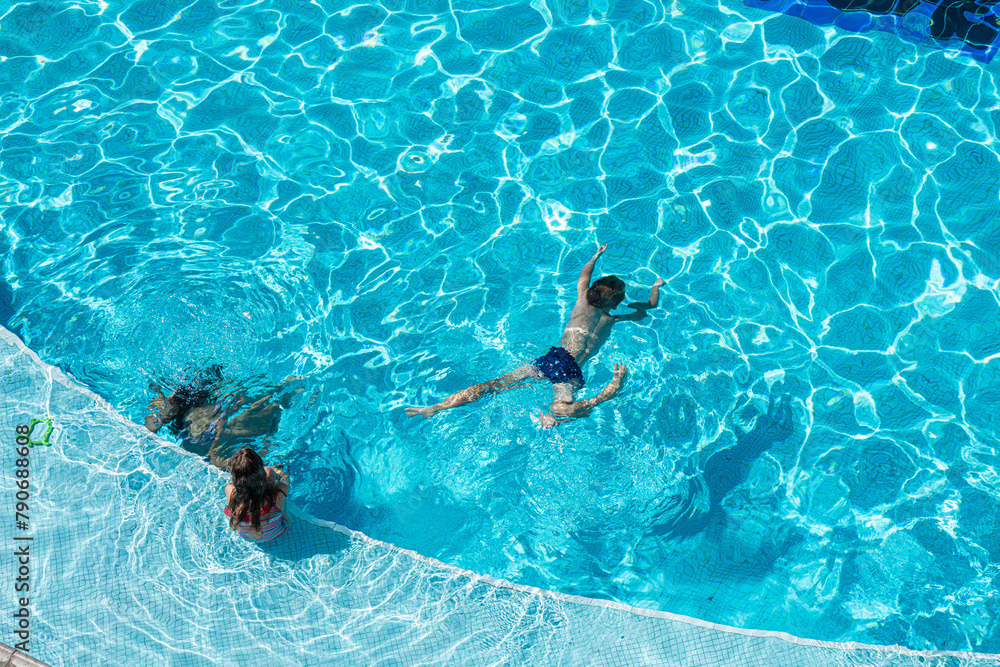 kids swimming in pool underwater.