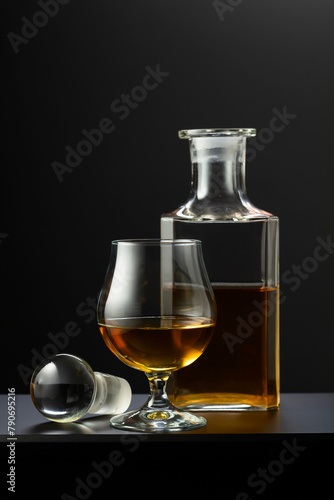 Old decanter and glass with whiskey, cognac or brandy.