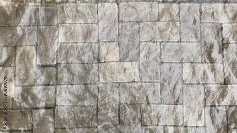 Top view or flat lay view of shallow water flow on grey paved background Top view or flat lay view of shallow water flow on grey paved background