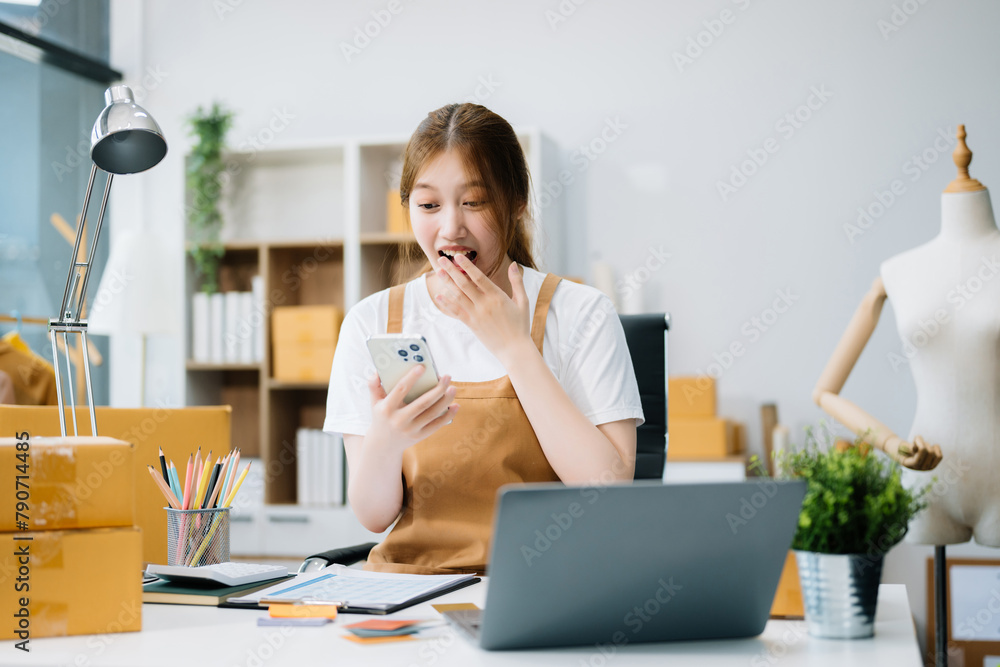 Startup small business SME, Entrepreneur owner woman using smartphone or tablet taking receive and checking online purchase shopping order Startup small business SME, Entrepreneur owner woman using smartphone or tablet taking receive and checking online purchase shopping order