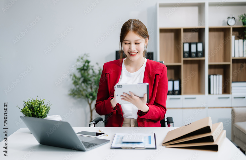 Asian businesswoman working with working notepad, tablet and laptop documents in the office Asian businesswoman working with working notepad, tablet and laptop documents in the office