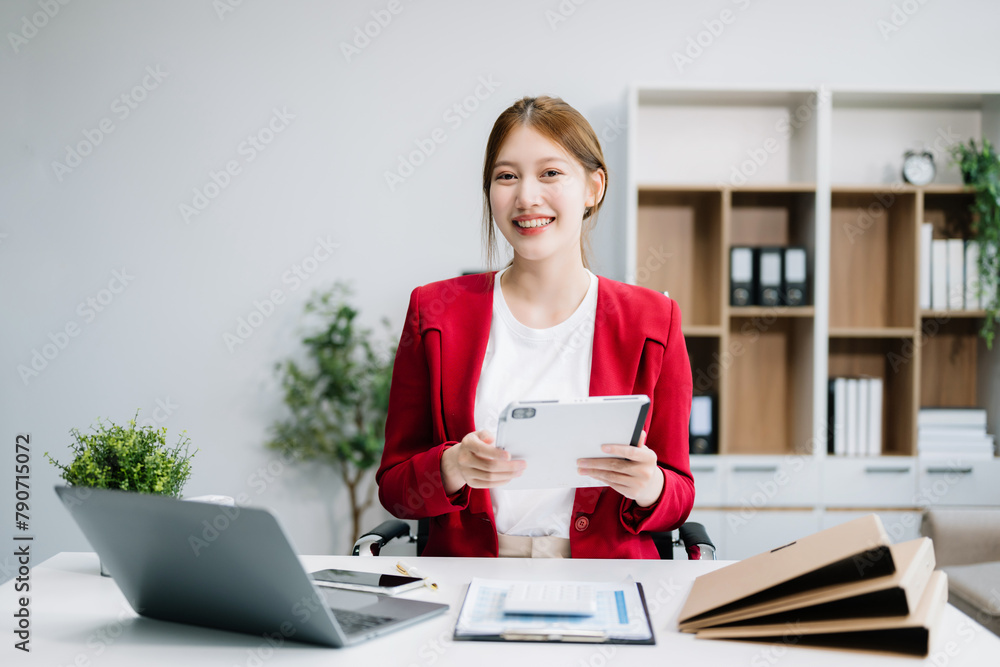 Confident Asian woman with a smile standing holding notepad and tablet at the ffice.. Confident Asian woman with a smile standing holding notepad and tablet at the ffice..