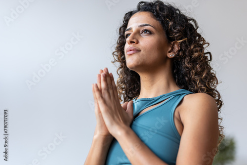 Zen peaceful woman dressed in a tracksuit doing yoga poses in the living room at home