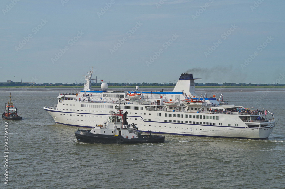 Small classic cruiseship cruise ship ocean liner Berlin arrival into Bremerhaven port, Germany with tug boats and marine traffic
