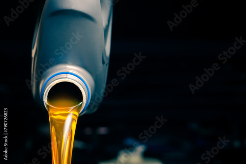 Pour engine oil from the lubricant bottle. Engine background, oil change shop engine service industry