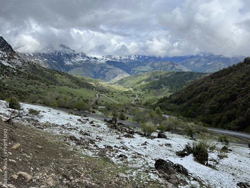 Obraz premium Tseylomsky pass in Ingushetia. A trip uphill to the Tsei Loam pass on a cloudy spring day. Panorama of the high cliffs of the Dzheyrakh gorge. North Caucasus, Russia