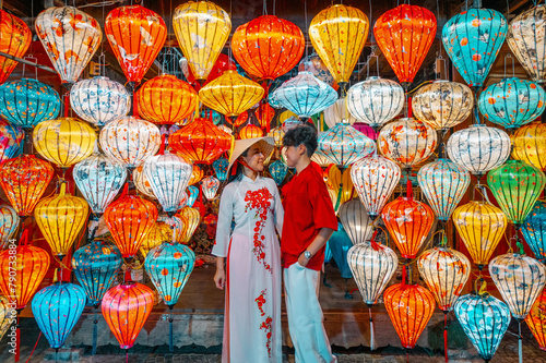 Asian Couple wearing vietnam traditional culture choosing lanterns at Hoi An ancient town,Hoi an city in Vietnam.