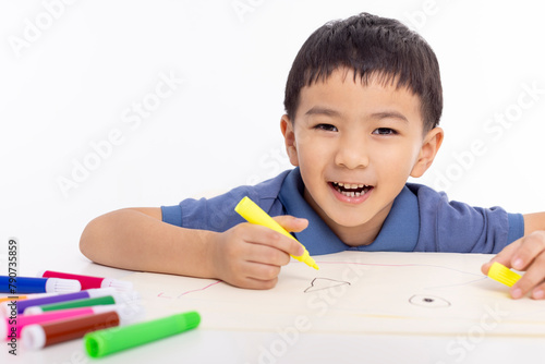 Smiling asian child schoolboy painting and drawing at home