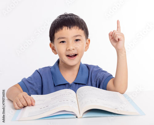 Excited asian child schoolboy studying  at home and hand pointing up