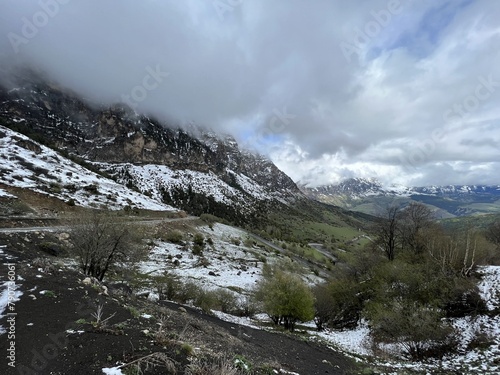 Tseylomsky pass in Ingushetia. A trip uphill to the Tsei Loam pass on a cloudy spring day. Panorama of the high cliffs of the Dzheyrakh gorge. North Caucasus, Russia