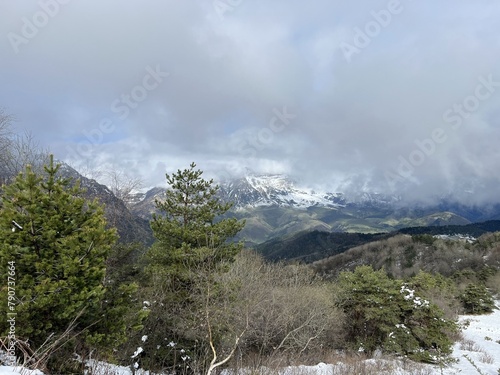 Tseylomsky pass in Ingushetia. A trip uphill to the Tsei Loam pass on a cloudy spring day. Panorama of the high cliffs of the Dzheyrakh gorge. North Caucasus, Russia photo