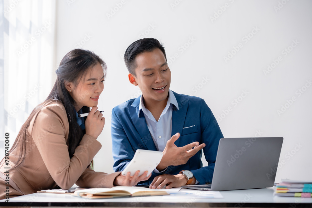 Two professionals analyzing documents together with laptop on desk in office. Business meeting and cooperation concept Two professionals analyzing documents together with laptop on desk in office. Business meeting and cooperation concept