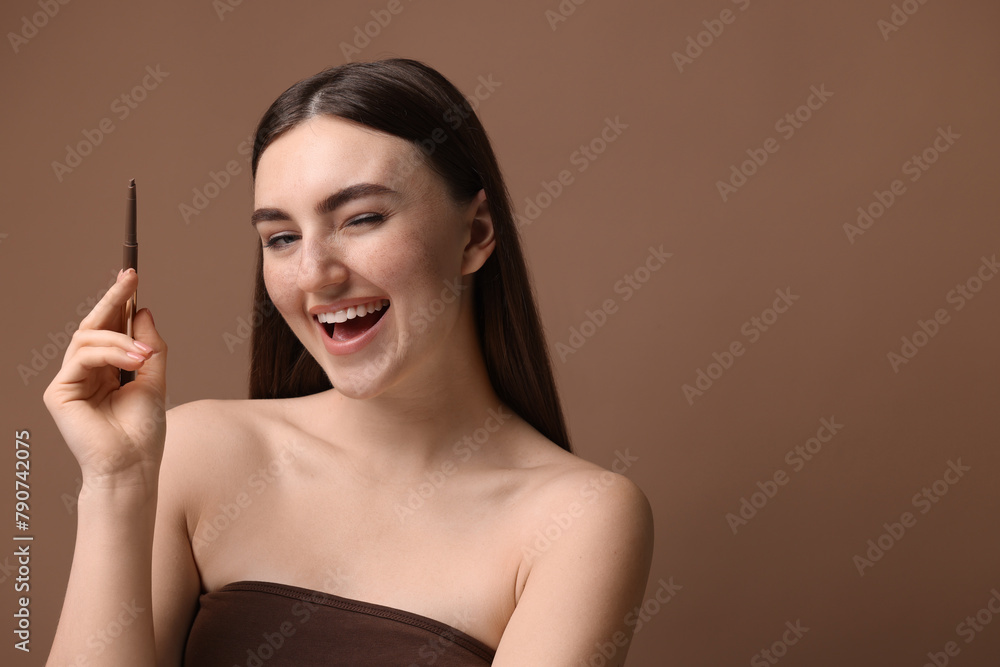 Happy woman with freckle pen on brown background. Space for text Happy woman with freckle pen on brown background. Space for text