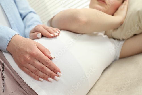 Doula taking care of pregnant woman indoors, closeup. Preparation for child birth