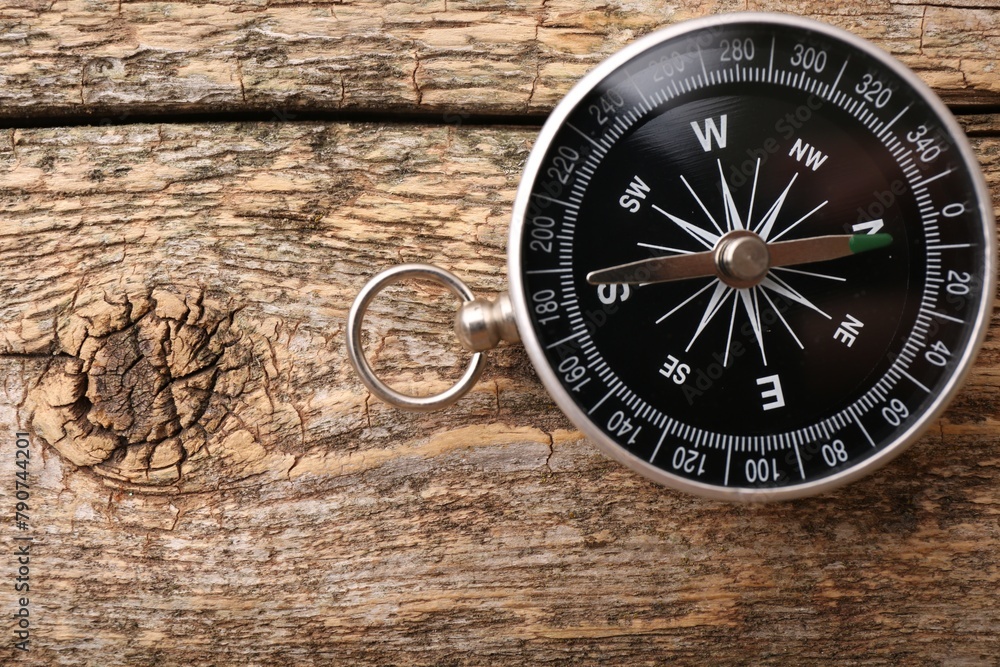 One compass on wooden table, top view. Space for text One compass on wooden table, top view. Space for text