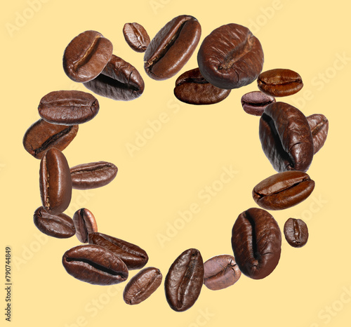 Roasted coffee beans in air on beige background