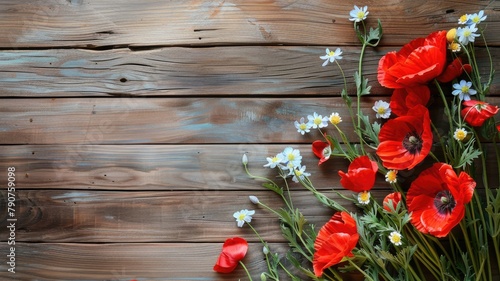 Red poppies and small white flowers scattered on rustic wooden background