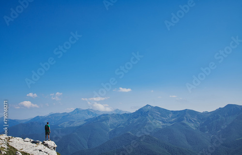 Unrecognizable man on a rock looking at mountains
