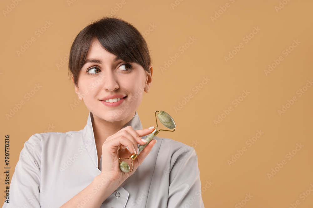 Cosmetologist with facial roller on beige background, space for text Cosmetologist with facial roller on beige background, space for text