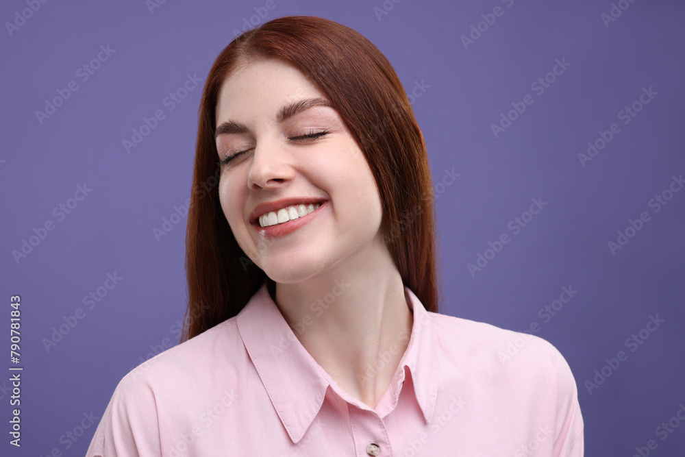 Fototapeta premium Portrait of smiling woman with freckles on purple background